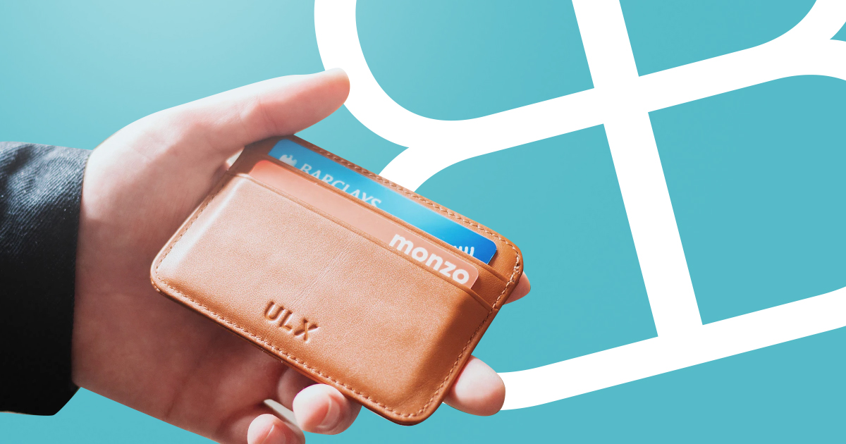 Person holding brown wallet with bank card