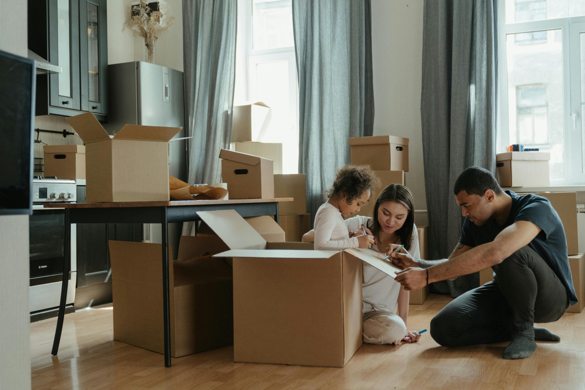 family unpacking boxes in new home